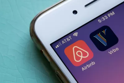 Close-up of mobile phone with Airbnb and VRBO app icons.