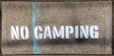 "No Camping" stencil on concrete.