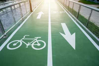 Green painted two-way bike lane with bike symbols and arrows.