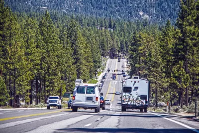 Road with traffic near Lake Tahoe, California with pine tree forest on either side.