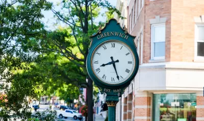 Close-up of green ornate clock with Greenwich written in gold on street in downtown Greenwich, Connecticut.
