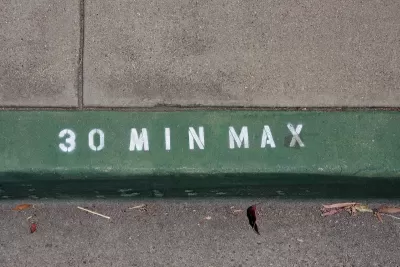 Close-up on green painted curb with '30 min max' in white.