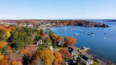 Aerial view of Maine harbor town with fall colors on trees.