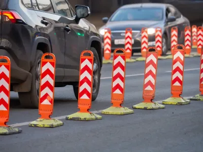 Orange and white plastic bollards delineating bike lane.