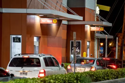 Line of cars at a McDonald's drive-thru at night.