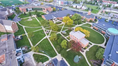 Aerial view of college campus with red brick buildings and green lawns.