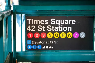 Close-up of New York City subway sign for Times Square 42nd St Station with colored dots indicating various train lines.