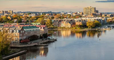 View of Alexandria, Virginia with brick three-story townhomes on Potomac River bank.