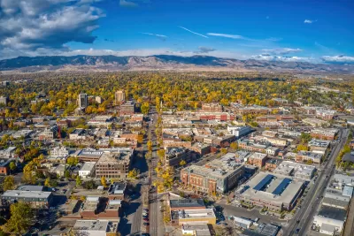 Aerial view of Fort Collins, Colorado on sunny day with mountains in background.