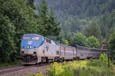 AMtrak train passing through dense green forest in Index, Washington.
