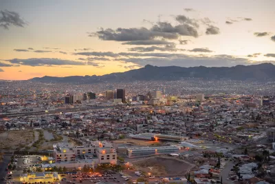 Aerial view of El Paso, Texas at dusk with mountains in background.