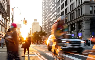 Fast paced scene with people bike and cars at the busy intersection of 14th Street and 5th Avenue in New York City.