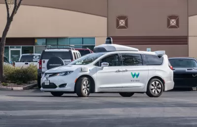 White Waymo self-driving car in parking lot in Chandler, Arizona.