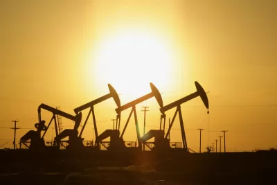 Four oil wells sillhouetted against the sunset.