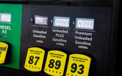 Close-up of gas pump with yellow buttons and price screens.