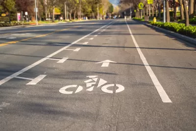 Bike lane marked with white paint on asphalt street.