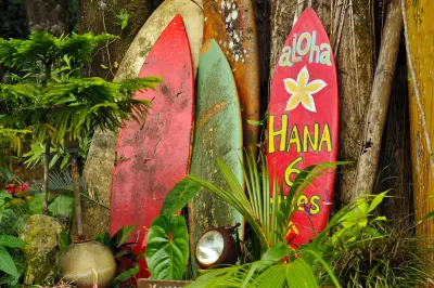 Red and yellow surfboards leaning against fence in Maui, Hawaii.