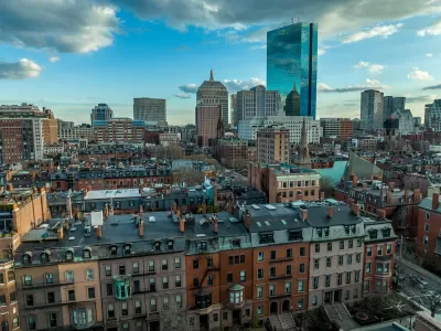 Aerial view of downtown Boston, Massachusetts with older buildings in foreground and modern glass towers in background.