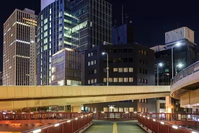Vacant pedestrian overpass and skyscrapers in downtown financial district at night.