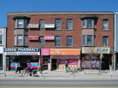 Two-story red brick buildings and street with bike lane in Toronto, Canada.