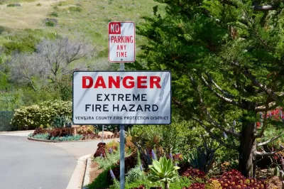 "Danger Extreme Fire Hazard" sign on street sign post below "No Parking" sign.