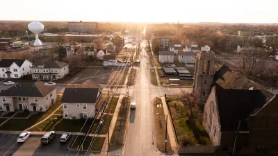 Aerial view of Gary, Indiana at golden hour with prominent white bulbous water tower on left historic stone church on the right.