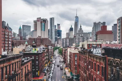 View of brick buildings and One World Trade Center building and New York City skyline.