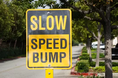 Yellow and black "SLOW SPEED HUMP" sign on residential street