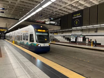 White and blue Seattle Link light rail train pulling into station in Seattle, Washington.