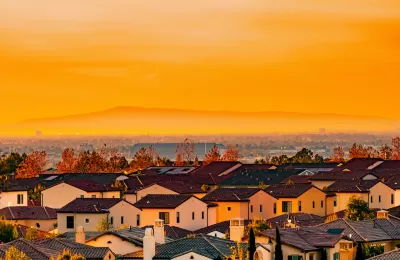 View of Spanish-style homes in dense neighborhood in Orange County, California at sunset.