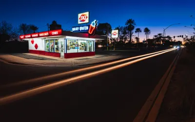 Historic Dairy Queen restaurant building with neon signs at night.