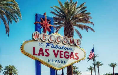 "Welcome to fabulous Las Vegas Nevada" sign with mottled shade from palm tree.