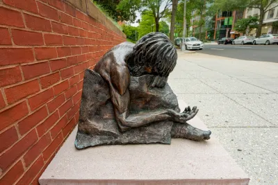 Bronze statue of homeless man (Jesus) with head down and arm outstretched in front of St. Matthew Cathedral in Washington D.C.