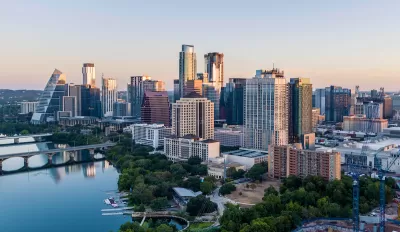 View of Austin, Texas skyline with river in foreground during morning golden hour.