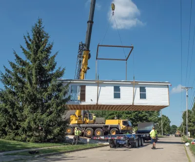 Modular home being lifted with crane.