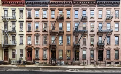 Row of 4-story brick New York City apartment buildings.
