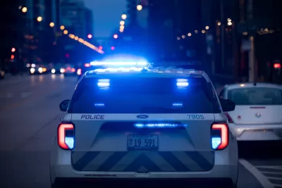 Chicago police car with blue lights on stopped on street in evening.