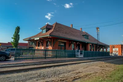 Small brick building with green roof housing old train station and visitor center in Van Buren, Arkansas
