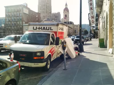 U-Haul moving van parked by a curb in San Francisco with mattress leaning against it