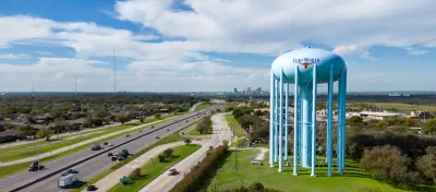 Aerial view of freeway and large blue water tower with Fort Worth logo on it in Fort Worth, Texas.