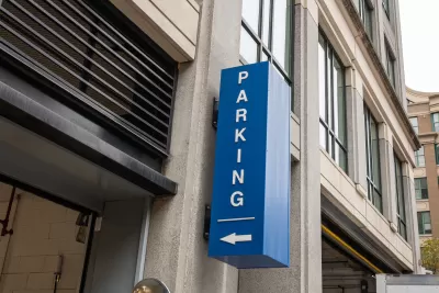 Blue sign with white Parking text and arrow pointing into garage