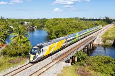 Aerial view of yellow Brightline high-speed rail train in Deerfield Beach, Florida.