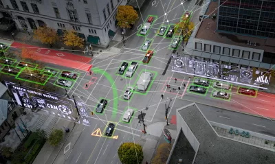 Aerial view of vehicles on city street with superimposed graphic arrows indicating autonomous cars.