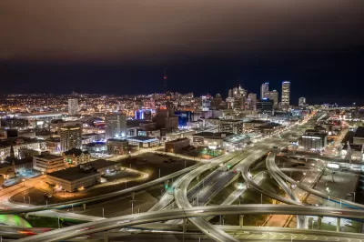 Aerial view of Milwaukee, Wisconsin skyline with freeway interchanges in foreground at night.
