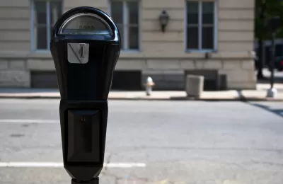 Close-up of black parking meter with blurred street in background