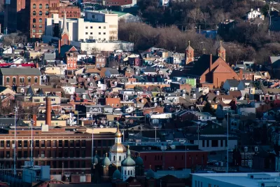 Aerial view of dense South Side Flats neighborhood in Pittsburgh, PA with Orthodox church spires in foreground.