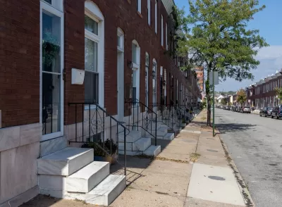Row of red brick rowhouses with white marble steps in Baltimore, Maryland.