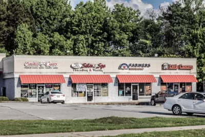 One-story strip mall with red awnings.