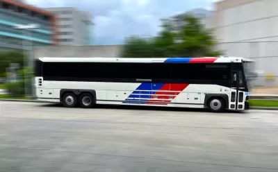Houston Metro bus moving rapidly across blurred background.