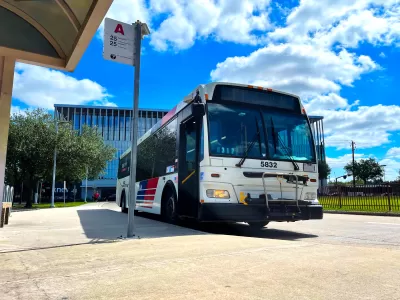 Houston Metro bus at a bus stop with bright blur cloudy sky in background